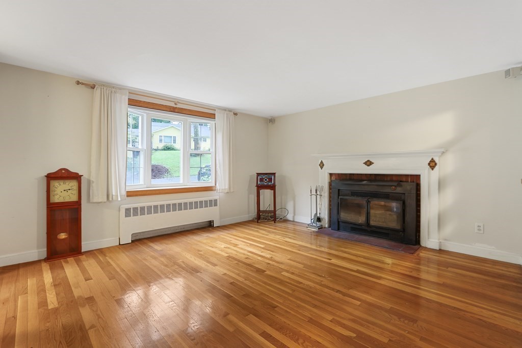 21 Cutler Drive Ashland, MA 01721 - Photo 4 of 34 a view of empty room with a fireplace and wooden floor