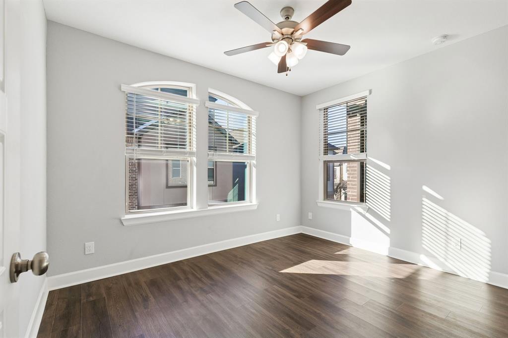 7119 Amber Grove Dallas, TX 75231 - Photo 24 of 30 an empty room with wooden floor chandelier fan and windows
