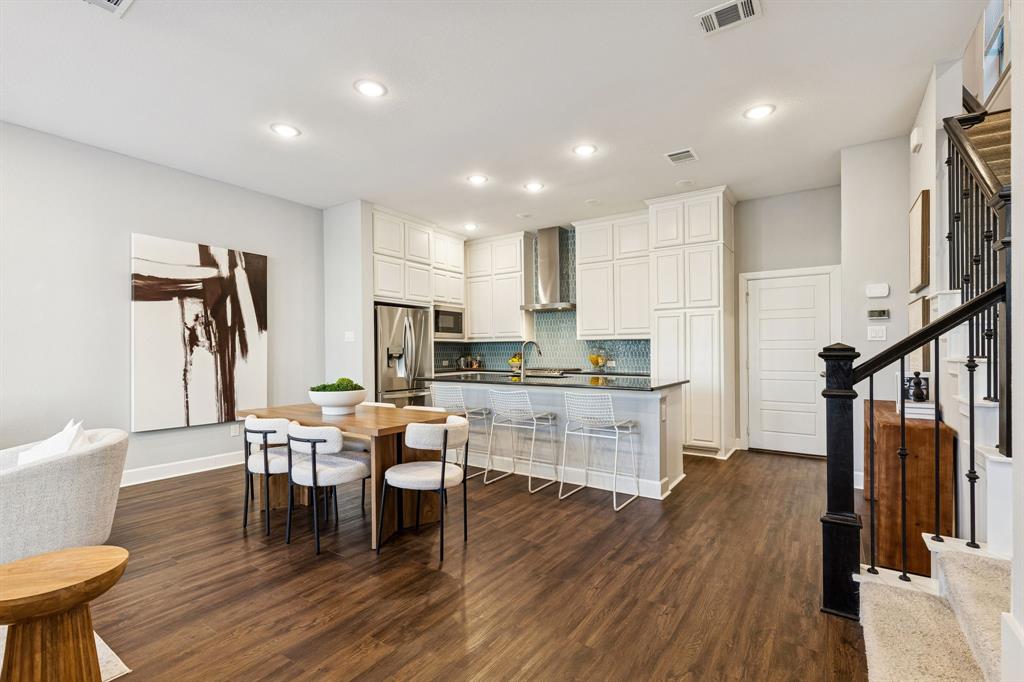 7119 Amber Grove Dallas, TX 75231 - Photo 7 of 30 a kitchen with a dining table chairs and refrigerator