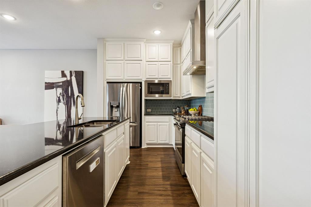 7119 Amber Grove Dallas, TX 75231 - Photo 10 of 30 a kitchen with stainless steel appliances granite countertop a refrigerator and a stove
