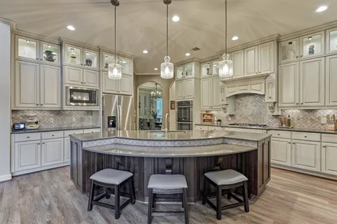 a kitchen with granite countertop a table chairs sink and cabinets