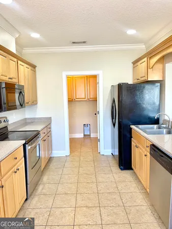 a kitchen with stainless steel appliances granite countertop a refrigerator and a stove top oven
