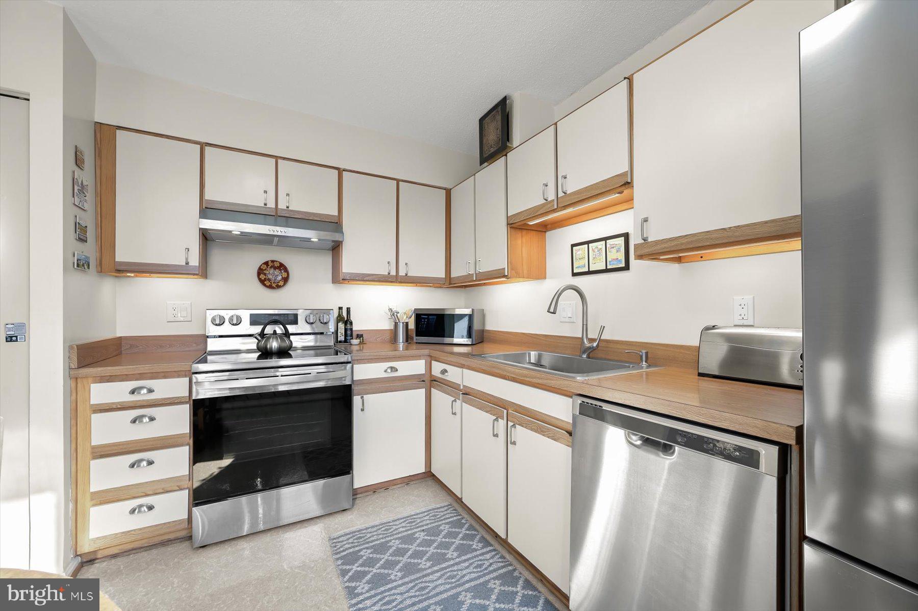 15107 Interlachen Drive, Unit 2725 Silver Spring, MD 20906 - Photo 19 of 35 a kitchen with stainless steel appliances granite countertop a sink stove and cabinets