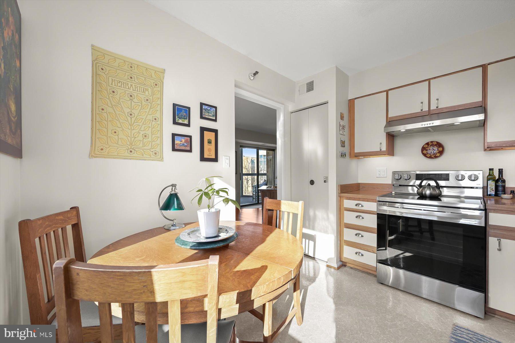 15107 Interlachen Drive, Unit 2725 Silver Spring, MD 20906 - Photo 22 of 35 a kitchen with stainless steel appliances kitchen island a table and chairs in it