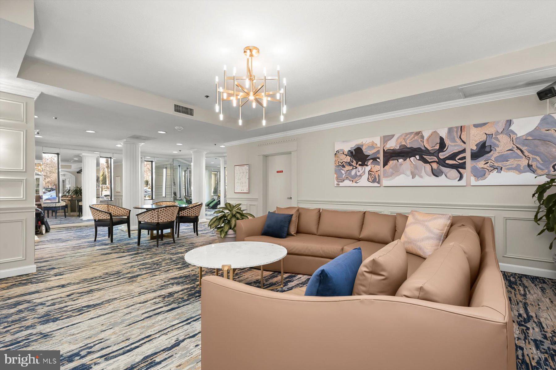 15107 Interlachen Drive, Unit 2725 Silver Spring, MD 20906 - Photo 7 of 35 a living room with furniture and a chandelier
