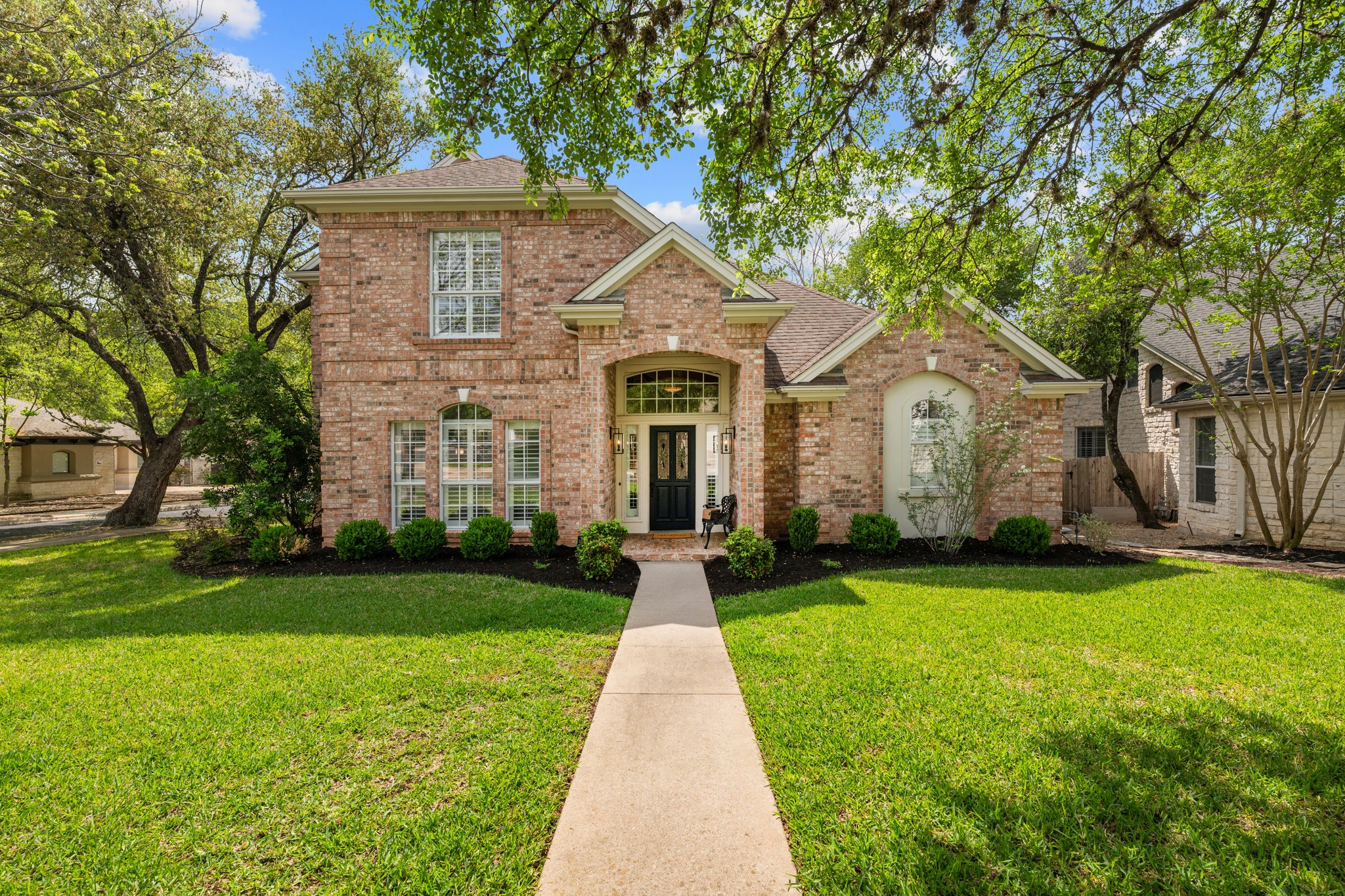 5909 Inter Council Cove Austin, TX 78731 - Photo 1 of 1 The property features a brick exterior, a well-maintained front lawn, and mature trees providing natural shade