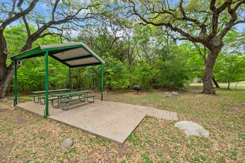 a backyard of a house with barbeque oven table and chairs