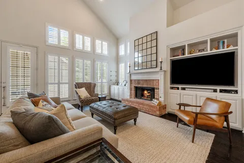 a living room with furniture a flat screen tv and a fireplace