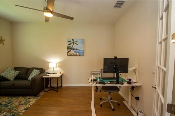 a view of a workspace with furniture and a window