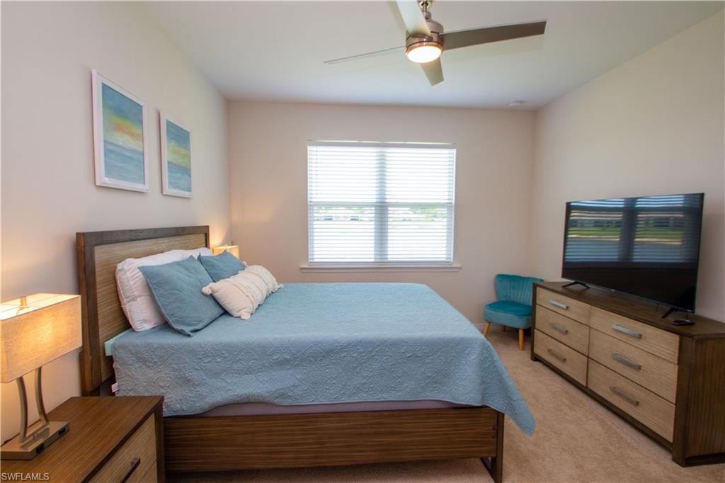 1241 Enbrook Loop Naples, FL 34114 - Photo 27 of 50 a bedroom with a bed and a flat screen tv