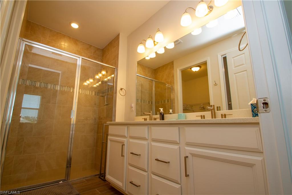 1241 Enbrook Loop Naples, FL 34114 - Photo 28 of 50 a bathroom with a double vanity sink mirror and shower