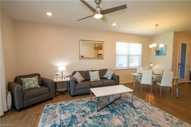 a living room with furniture a rug and a chandelier