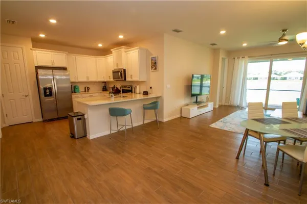 a kitchen with stainless steel appliances a stove a refrigerator a sink dishwasher with a dining table and chairs