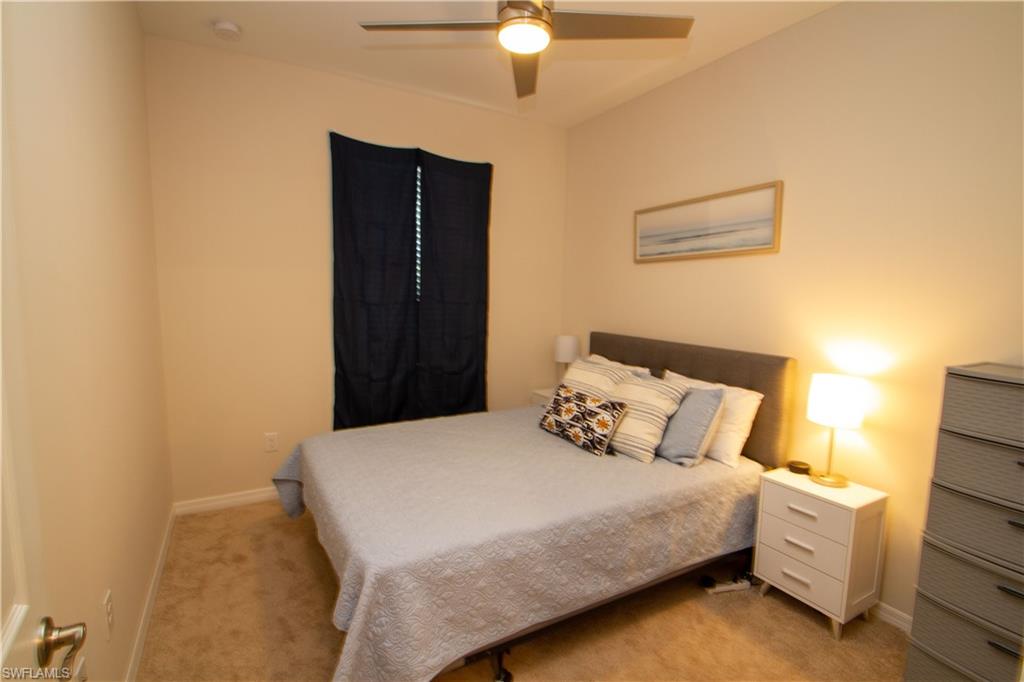 1241 Enbrook Loop Naples, FL 34114 - Photo 34 of 50 a bedroom with a bed and a chandelier