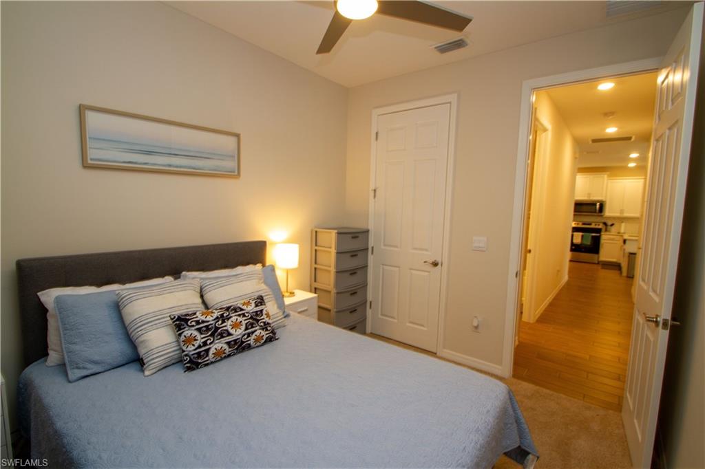 1241 Enbrook Loop Naples, FL 34114 - Photo 35 of 50 a bedroom with a bed and a chandelier