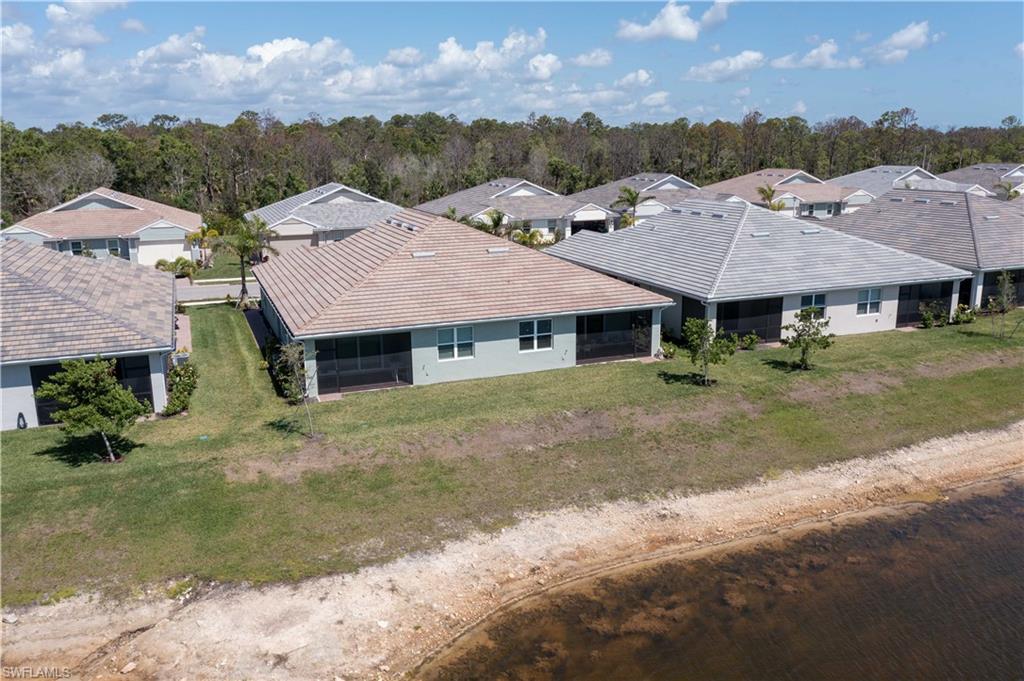 1241 Enbrook Loop Naples, FL 34114 - Photo 39 of 50 a view of a big house with a big yard and large tree