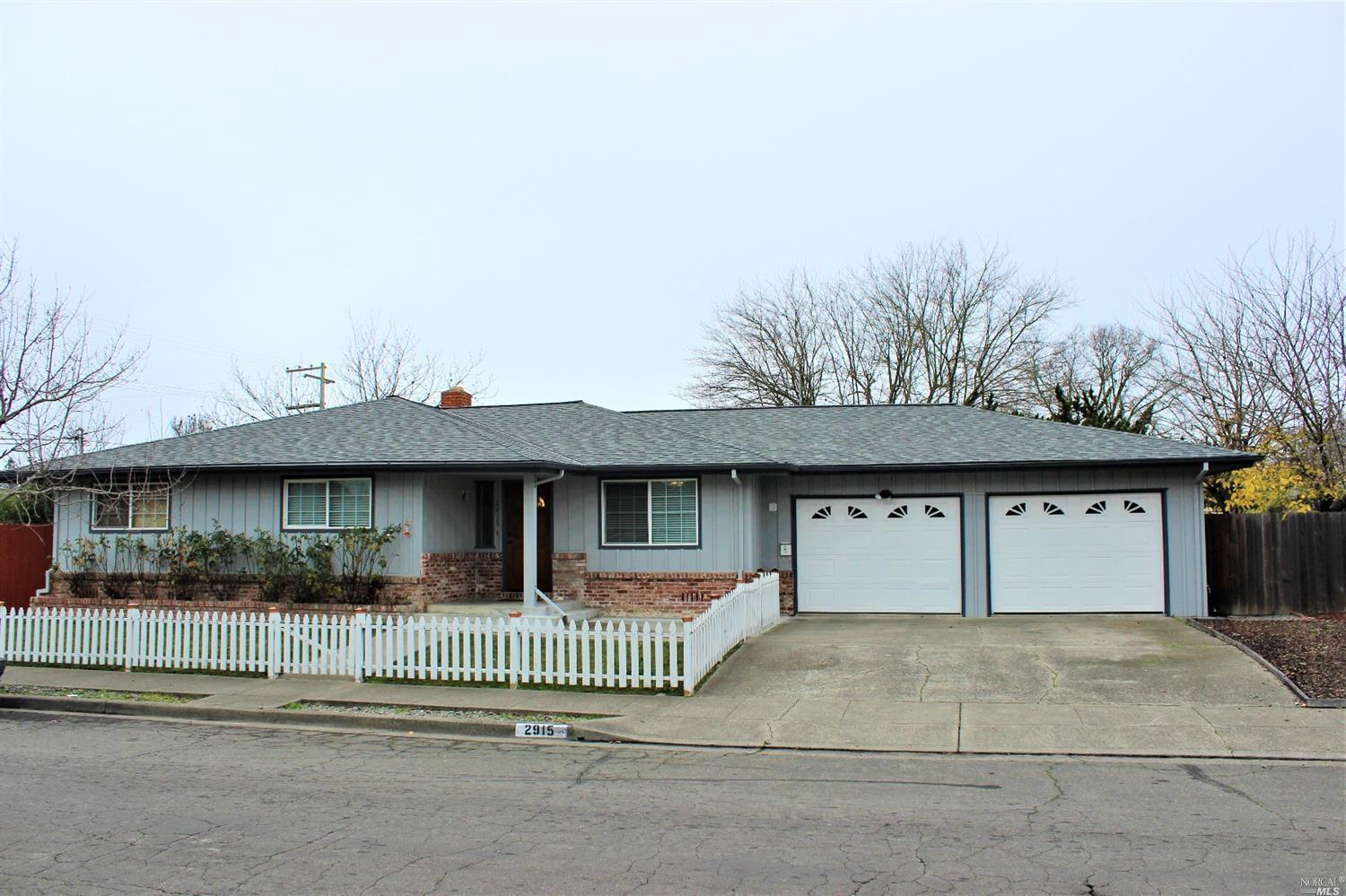 a view of a house with a yard and potted plants