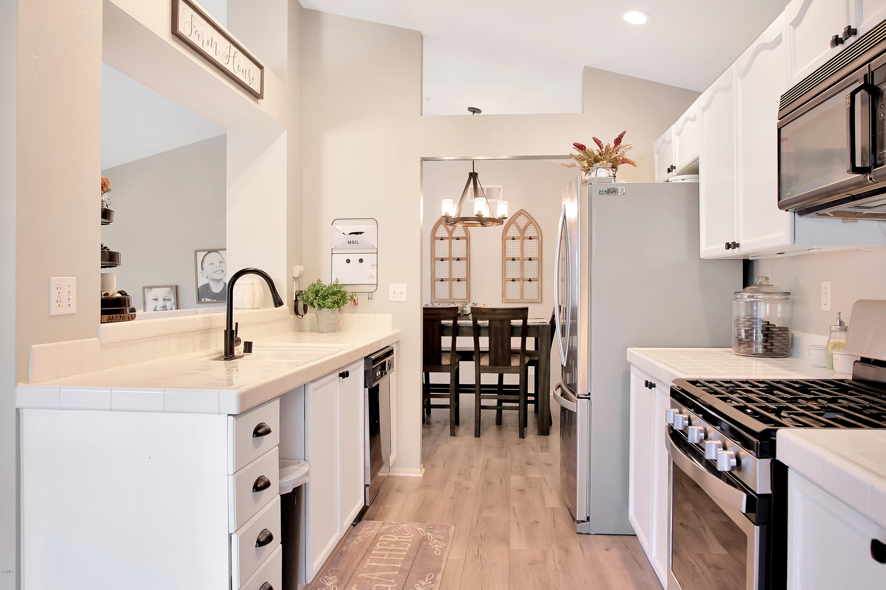 1303 Lost Point Lane Oxnard, CA 93030 - Photo 5 of 28 a kitchen with stainless steel appliances kitchen island a white stove top oven a sink with island and chairs