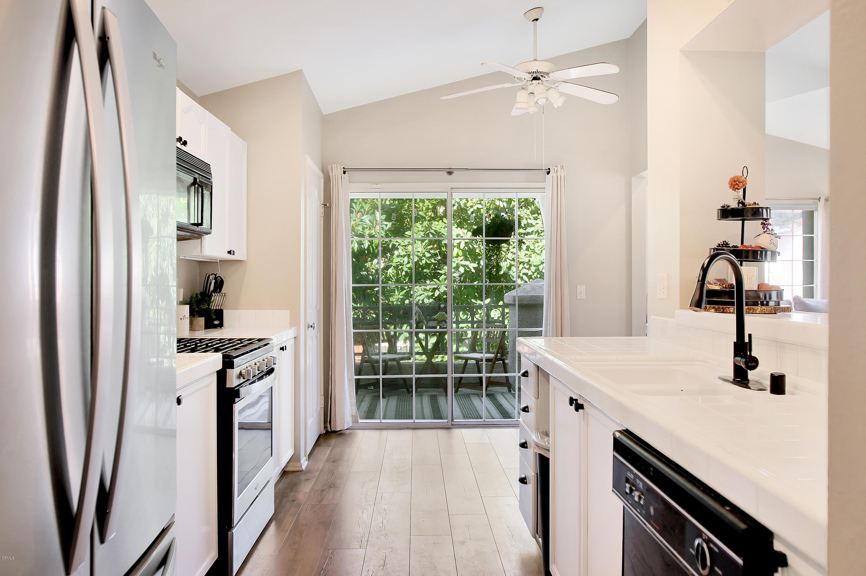 1303 Lost Point Lane Oxnard, CA 93030 - Photo 7 of 28 a kitchen with kitchen island a stove a sink and a refrigerator