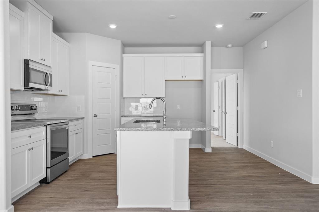 227 Faith Lane Tioga, TX 76271 - Photo 12 of 26 a kitchen with kitchen island white cabinets and stainless steel appliances