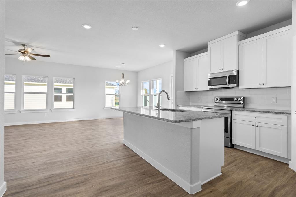 227 Faith Lane Tioga, TX 76271 - Photo 14 of 26 a kitchen with granite countertop a stove top oven sink and cabinets