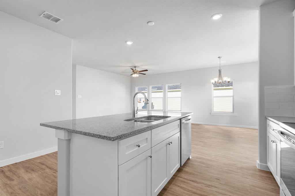 227 Faith Lane Tioga, TX 76271 - Photo 15 of 26 a kitchen with a granite countertop sink and dishwasher with wooden floor