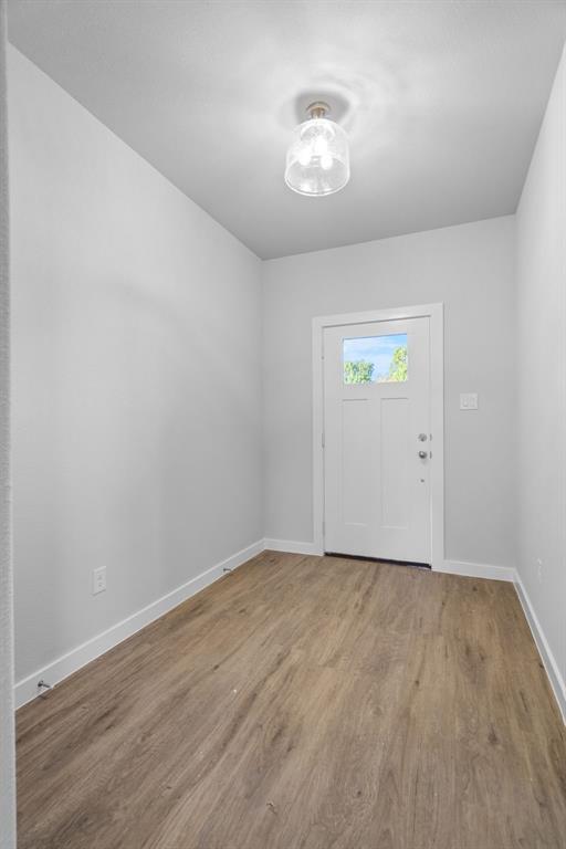 227 Faith Lane Tioga, TX 76271 - Photo 4 of 26 a view of an empty room with wooden floor and a window