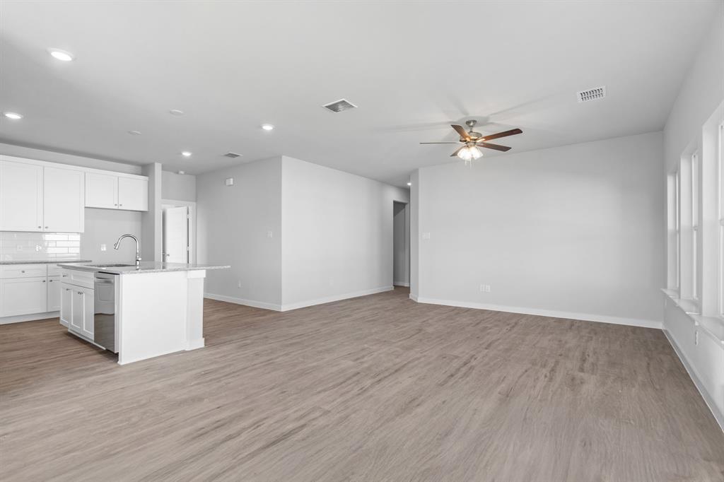 227 Faith Lane Tioga, TX 76271 - Photo 7 of 26 a view of an empty room with kitchen window and wooden floor