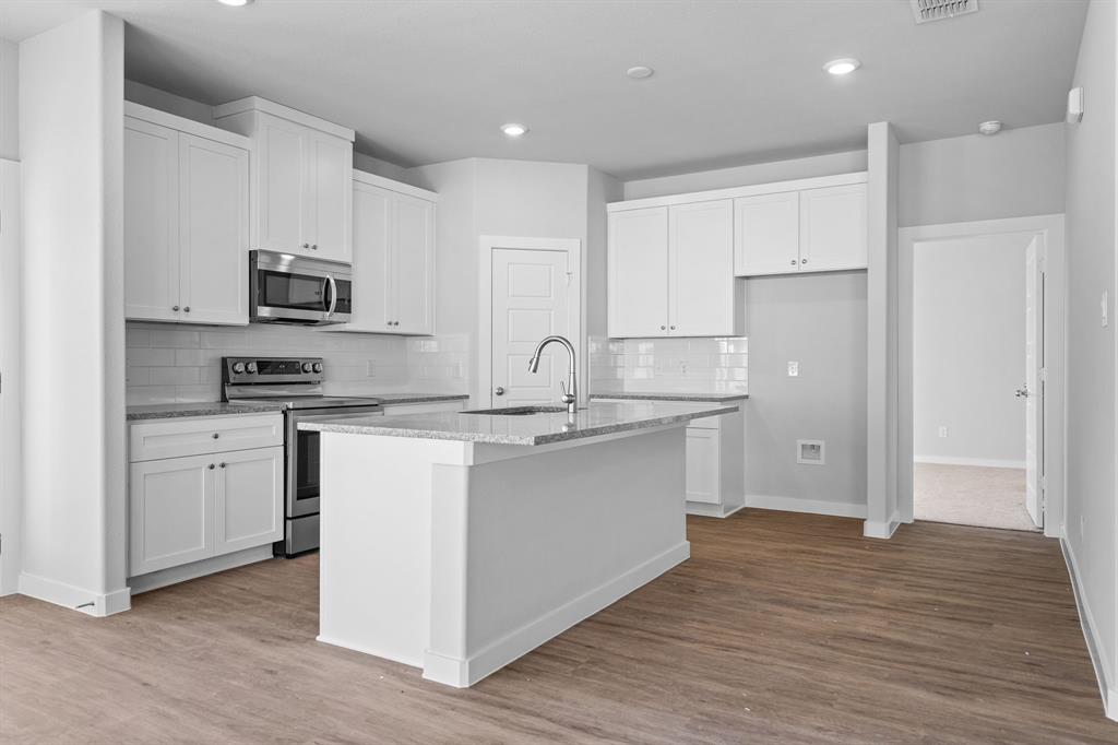 227 Faith Lane Tioga, TX 76271 - Photo 9 of 26 a kitchen with stainless steel appliances granite countertop a sink stove and refrigerator