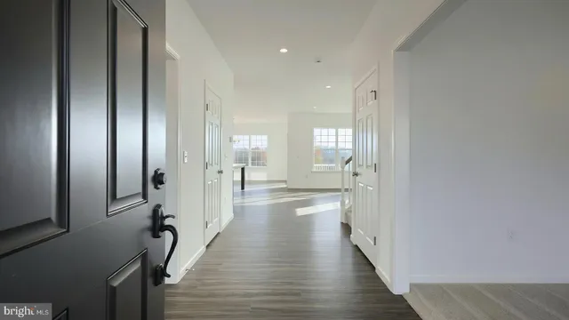 a view of a hallway with wooden floor and closet
