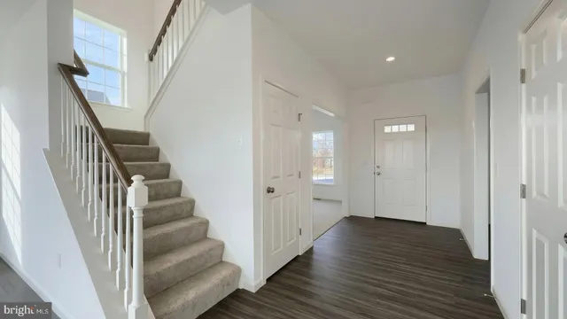 a view of a hallway with wooden floor and entryway
