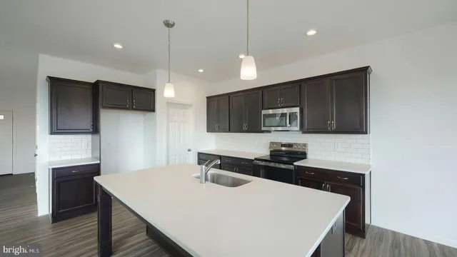 a kitchen with a sink a microwave a stove and refrigerator