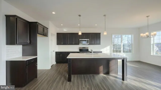 a kitchen with kitchen island granite countertop a sink stainless steel appliances and cabinets