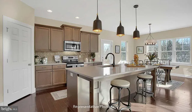 a kitchen with stainless steel appliances granite countertop a sink a stove and a refrigerator