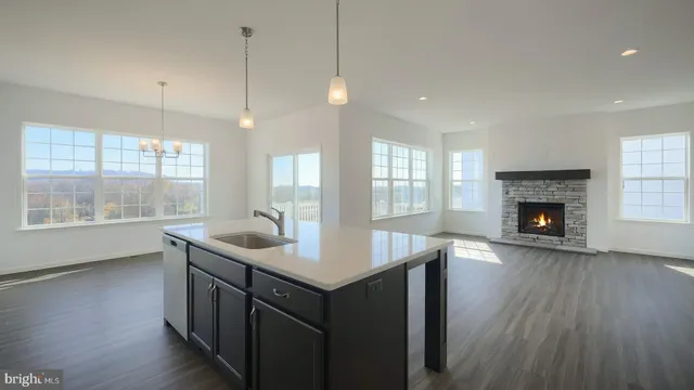 a kitchen with a sink window and wooden floor