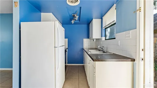 a kitchen with a refrigerator and a sink