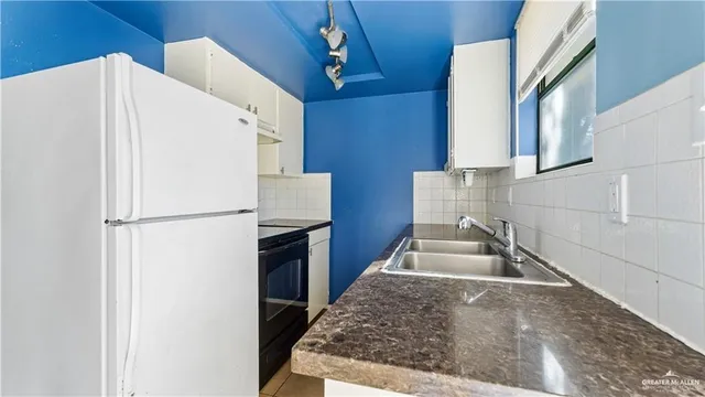 a kitchen with granite countertop a refrigerator and a stove
