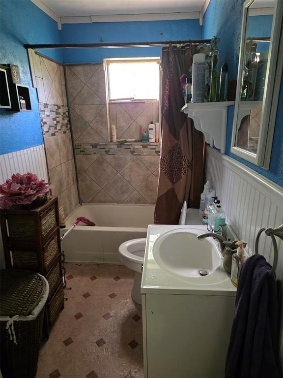 1417 Ray Street Longview, TX 75603 - Photo 7 of 12 Bathtub with tiled surround, wall-mounted window, and single vanity with integrated sink