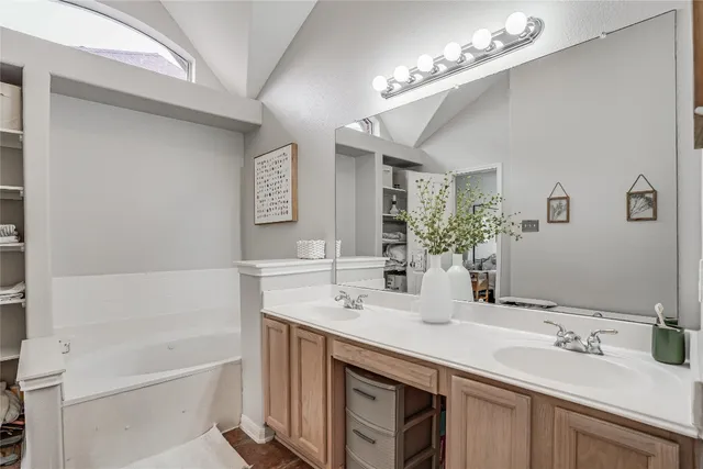 a bathroom with a tub sink and mirror
