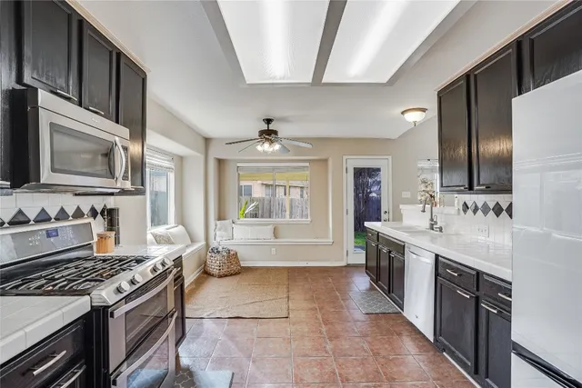 a large kitchen with stainless steel appliances granite countertop a stove and a sink