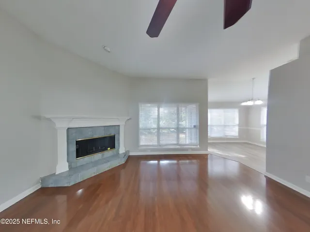 a view of empty room with wooden floor and fireplace