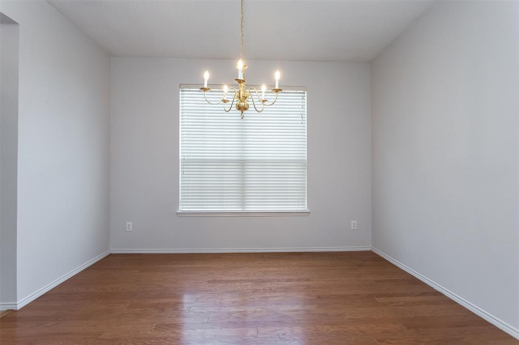 738 Opal Lane Mesquite, TX 75149 - Photo 4 of 31 Spare room featuring dark wood-type flooring and a chandelier