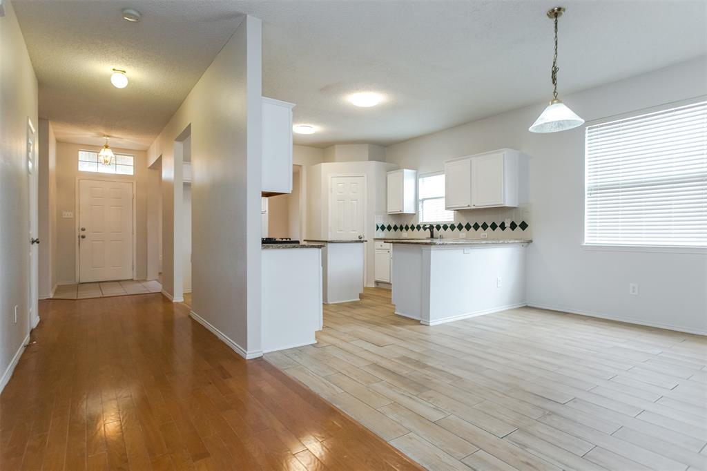 738 Opal Lane Mesquite, TX 75149 - Photo 8 of 31 Kitchen with hanging light fixtures, white cabinetry, light wood finished floors, and a peninsula