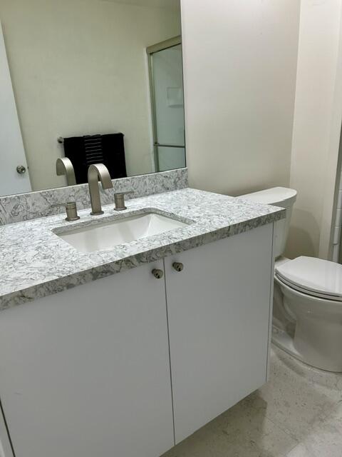 2700 Lawrence Crossley Road, Unit 18 Palm Springs, CA 92264 - Photo 6 of 7 a bathroom with a granite countertop sink a toilet and mirror