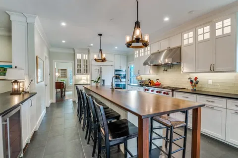 a kitchen with stainless steel appliances a table chairs refrigerator and cabinets