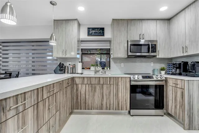 a kitchen with stainless steel appliances kitchen island granite countertop a stove sink and cabinets