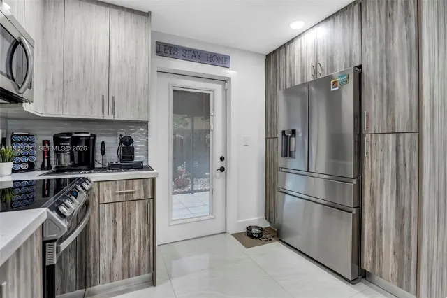 a kitchen with stainless steel appliances granite countertop a refrigerator and a sink