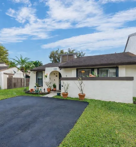 a front view of a house with a garden and yard