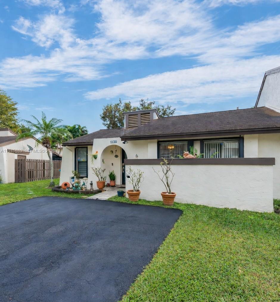 12736 Southwest 68th Lane Miami, FL 33183 - Photo 2 of 37 a front view of a house with a garden and yard