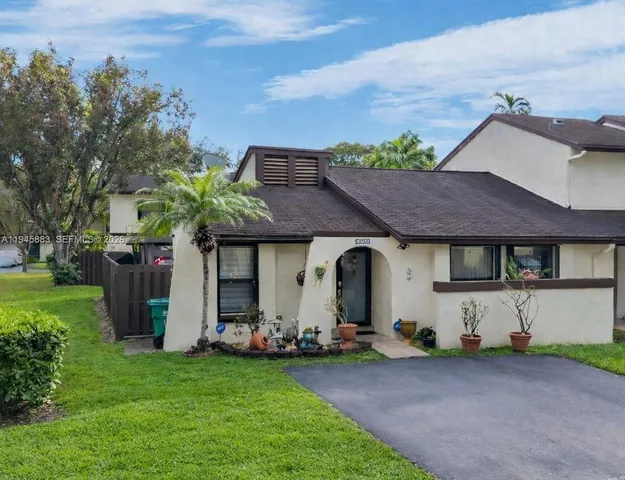 a front view of a house with a garden and plants